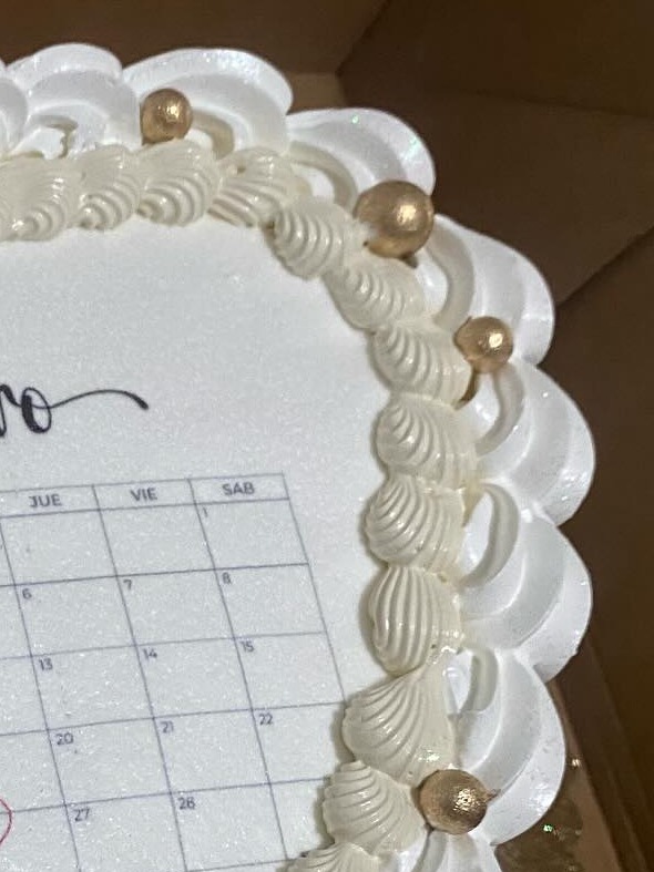 Detalle del borde calado con perlas doradas de una torta de corazón