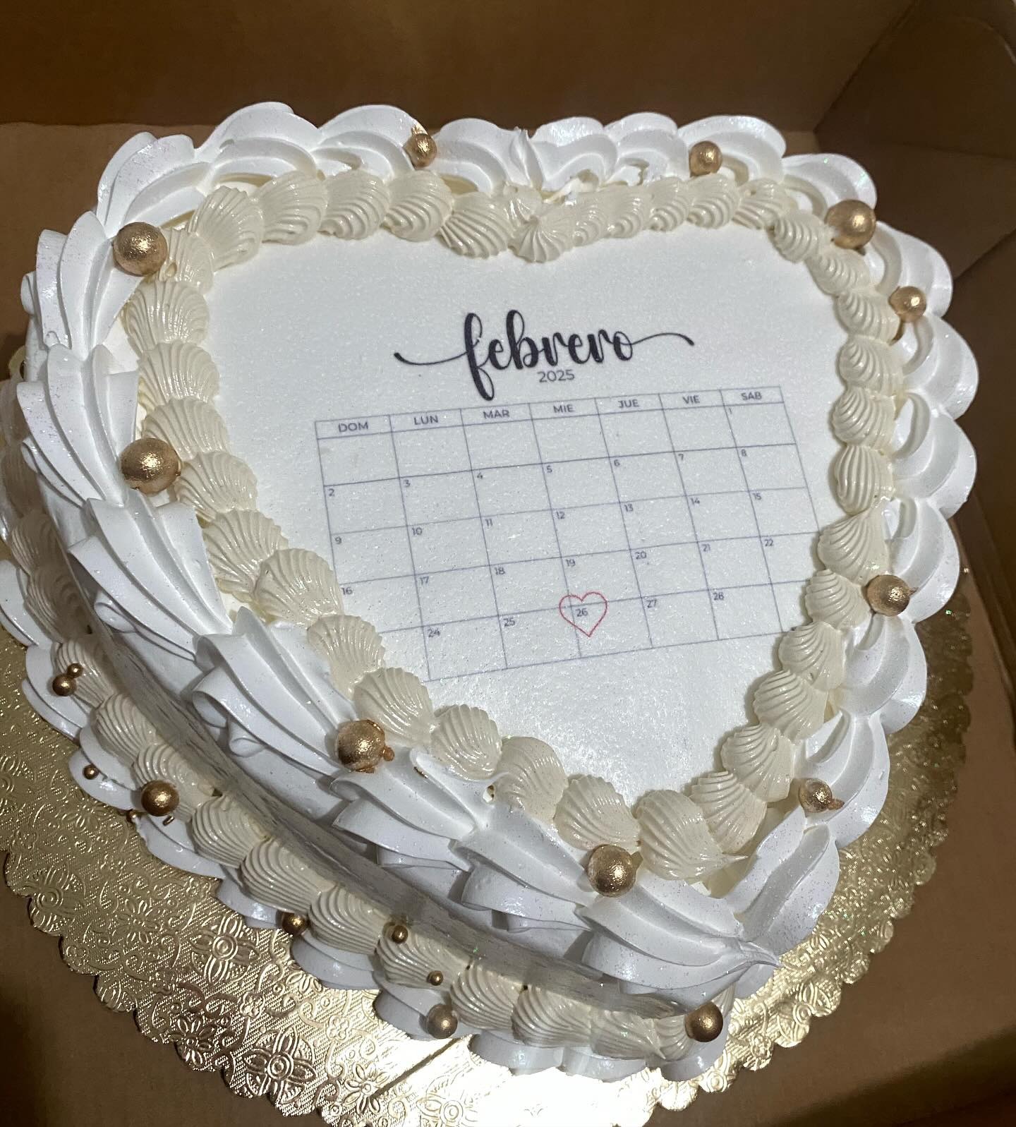 Torta de corazón con calendario de febrero y borde de perlas doradas